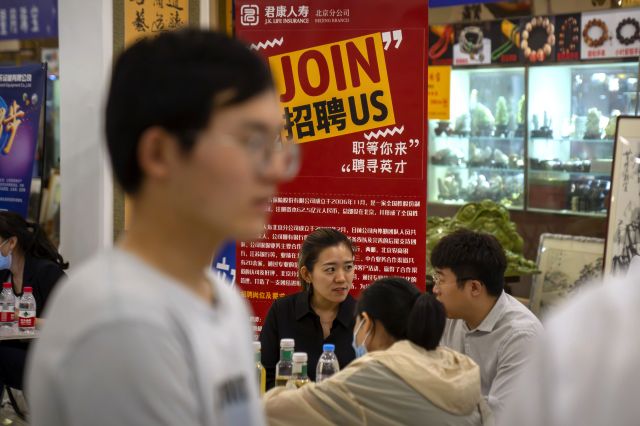 중국 베이징의 한 쇼핑 센터에서 9일 열린 채용박람회에서 기업 관계자와 취업준비생들이 부스에 앉아 대화하고 있다. AP연합뉴스
