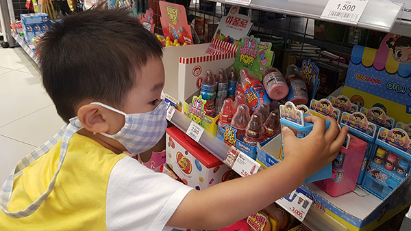 A kid picks up a “Toy Candy” at a convenience store. [Photo provided by Emart24]