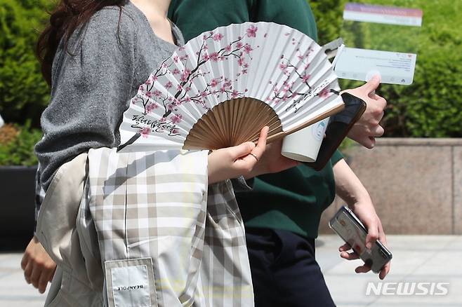 [서울=뉴시스] 권창회 기자 =서울 낮 기온이 25도까지 오른 2일 오후 서울 종로구 광화문역 인근에서 시민이 부채질을 하고 있다. 2023.05.02. kch0523@newsis.com