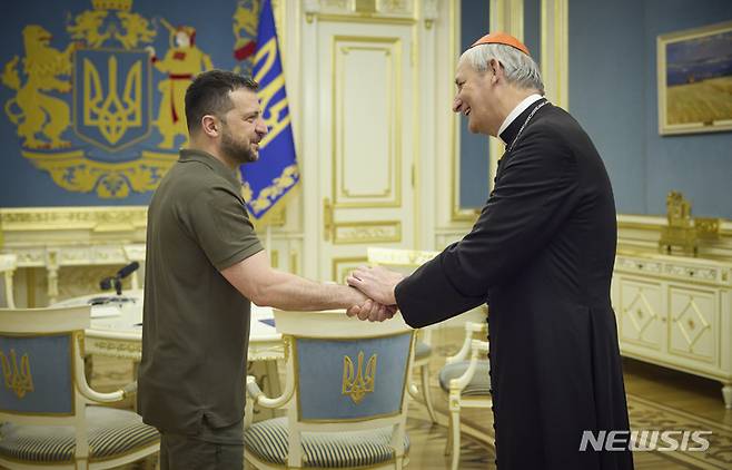 [키이우=AP/뉴시스] 볼로디미르 젤렌스키(왼쪽) 우크라이나 대통령이 지난 6일(현지시각) 키이우에서 교황의 평화 특사인 마테오 주피 추기경과 악수하고 있다. 사진은 우크라이나 대통령실이 제공했다. 2023.06.12.