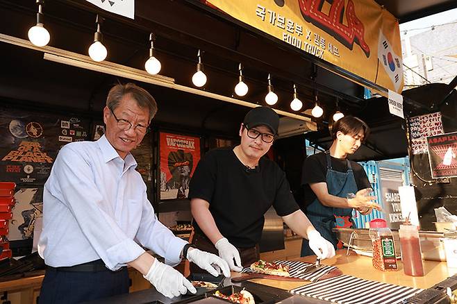 지난 9일 나치만 서울보훈청장이 웹툰 인기 작가 김풍씨와 정전70주년 의미가 담긴 70피자를 포장하고 있는 모습. 사진=서울지방보훈청