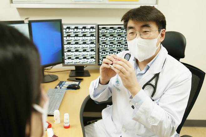 서울아산병원 알레르기내과 송우정 교수가 코로나19로 인한 기침 환자를 진료하고 있다.