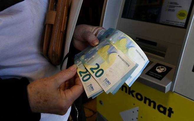 크로아티아 수도 자그레브에서 한 여성이 현금자동인출기에서 유로화 지폐를 인출하는 모습.[이미지 출처=AFP연합뉴스]