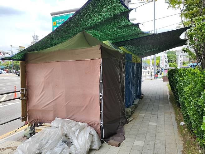 지난 12일 서울시 양재동 현대차그룹 본사 근처에 설치된 천막이 보행자의 통행을 방해하고 있다./정재훤 기자