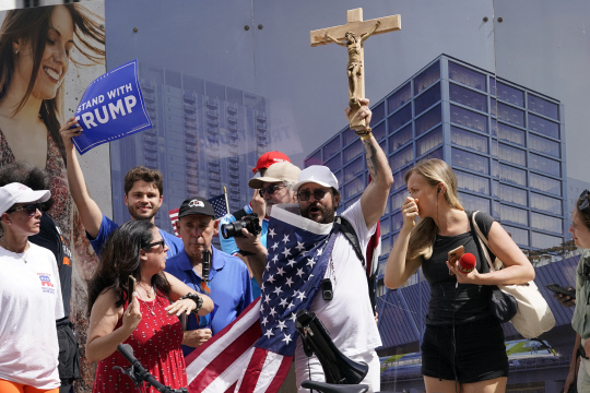 미 플로리다주 마이애미 연방법원 앞에서 트럼프 전 대통령 지지자들이  십자가에 못 박힌 예수상을 들고 시위하고 있습니다. AP 연합뉴스