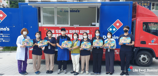 도미노피자 임직원들이 지난 13일 서울 동대문구 동부병원을 찾아 헌혈자들에게 피자를 기부하고 있다. 도미노피자 제공