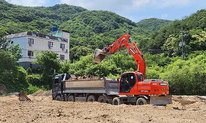 비포장 비료를 부적정 살포한 비료 제조 사업장이 14일 장군면 금암리 소재 농경지에서 중장비를 동원해 문제가 된 비료를 걷어내고 있다. 세종시 제공