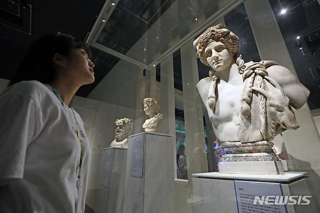 [서울=뉴시스] 박진희 기자 = '바쿠스' 대리석 흉상. 로마에서 포도주와 연극의 신으로 숭배된 바쿠스를 젊고 이상적인 모습으로 표현했다. 얼굴은 갸름하고 입은 약간 벌어져 있으며, 이마에 두른 머리띠 위로 보 이는 머리카락은 물결 모양으로 곱슬거린다. 머리에는 포도나무 잎과 부채 모양 꽃들로 만든 관을 썼던 흔적이 남아 있다. 후대에 추가된 가슴 부분에 염소 가죽을 둘렀는데, 이는 염소가 바쿠스가 관장하는 세계에 속한 동물이기 때문이다. 바쿠스의 무리에는 동물 외에도 포도주를 마시며 황홀경에 빠져 격정적인 축제를 즐기는 반인반수들이 있었다. 로마인들은 정기적으로 바쿠스 신을 기리는 축제였던 '바카날리아'에 참여했는데, 그 의례가 무절제하고 극단적이어서 사회 문제가 되자 결국 바쿠스 축제를 공식적으로 금지시켰다. 2023.06.17. pak7130@newsis.com