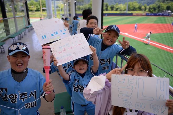 별내 리틀야구 선수들이 17일 인제군 야구장에서 열린 2023 인제군 1박2일 야구대회 도중 아빠들을 응원하는 글씨가 적힌 스케치북을 들고 기념사진을 촬영하고 있다. 인제 | 김만석 선임기자 icando@kyunghyang.com