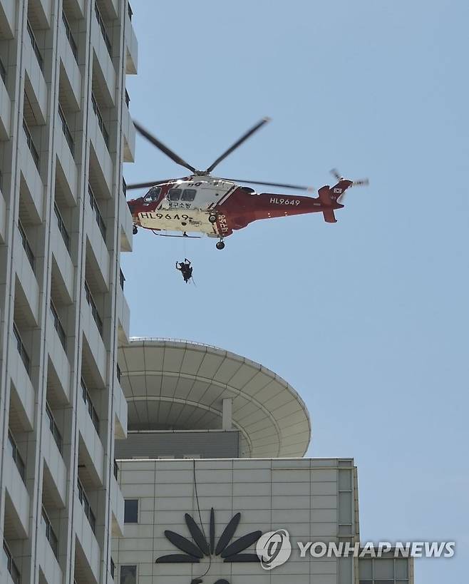 구조되는 옥상 대피 투숙객들 (부산=연합뉴스) 20일 오전 9시34분께 부산 해운대구 한 호텔 건물 지하에서 불이 나 소방헬기가 옥상에 대피한 투숙객들을 구조하고 있다. 2023.6.20 [부산 해운대구 제공. 재판매 및 DB금지] psj19@yna.co.kr