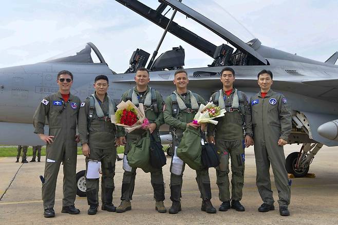 우리 공군 교관들이 지난 19일 경북 예천 소재 제16전투비행단에서 TA-50 비행훈련을 마친 폴란드 공군 바르토슈 구와 대령, 세바스티안 라이헬 대위를 축하하며 기념촬영을 하고 있다. (공군 제공)
