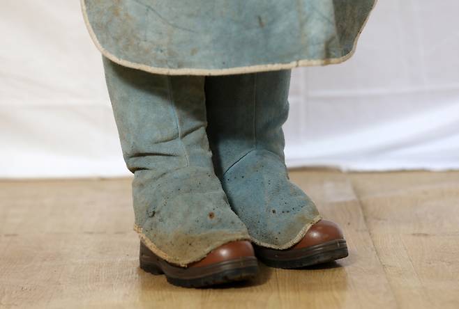 옷 이외에 안전 장비를 착용하는 것도 여성 용접사들의 큰 고충이다. 정지영씨(가명)는 “용접 장갑을 끼면, 1~2㎝ 가량 남아 손가락이 헛돈다”고 토로했다(위 사진). 소민정씨는 사이즈가 큰 바지를 고정하기 위해 청각반을 신는데, 그마저도 제대로 너무 커서 발목 아래까지 흘러 내려온다(아래 사진). 안전화를 완전히 덮을 정도로 헐거운 각반은 움직일 때 거추장스럽다. 본인 제공·권도현 기자