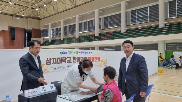 신창선 강원 양양농협 조합장(맨 오른쪽), 홍순정 NH농협 양양군지부장(〃왼쪽)이 한방진료를 받는 한 조합원을 살펴보고 있다.