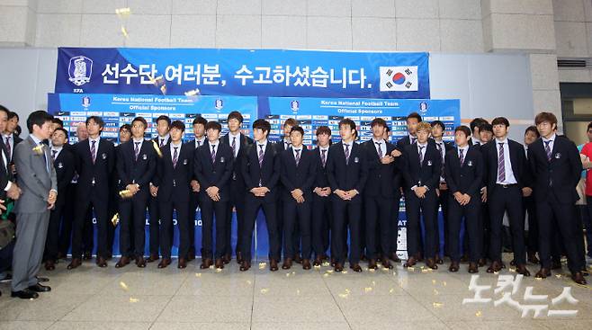 새벽 인청공항을 통해 귀국한 뒤 기념 촬영을 준비하던 축구 대표팀 앞으로 한 인터넷 커뮤니티 회원들이 투척한 엿이 날아들고 있다. 박종민 기자