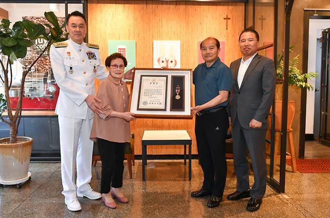 23일 김명수 해군작전사령관이 6·25전쟁 참전용사인 고 김재택 상사의 유가족을 찾아 무공훈장을 전달하고 있다. 왼쪽부터 김명수 해군작전사령관, 고 김재택 상사의 아내 한정순, 장남 김훈석, 차남 김해용 씨. 해군작전사령부 제공