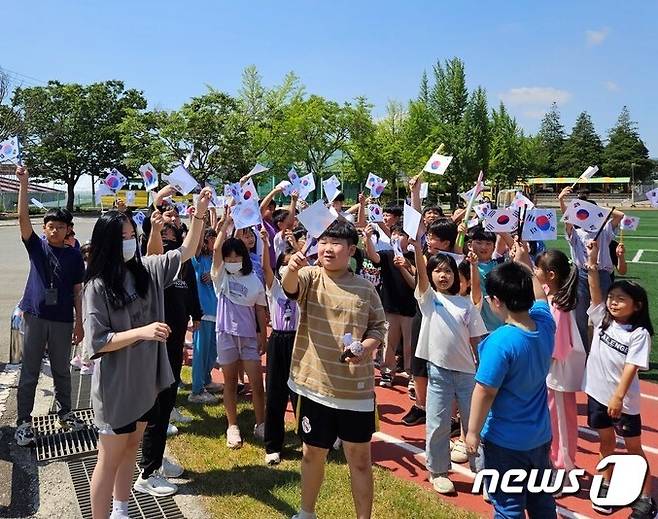 함평 월야초등학교(교장 임영희)- 학생들이 호국보훈의 달을 맞아 직접 그린 태극기를 들고 운동장으로 나와 6·10 만세운동을 재연하고 있다.(전남교육청 제공)/뉴스1