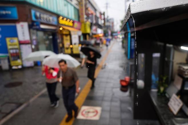 장마가 시작된 26일 오후 서울 관악구 신림역 인근에서 시민들이 우산을 쓰고 걷고 있다. 연합뉴스