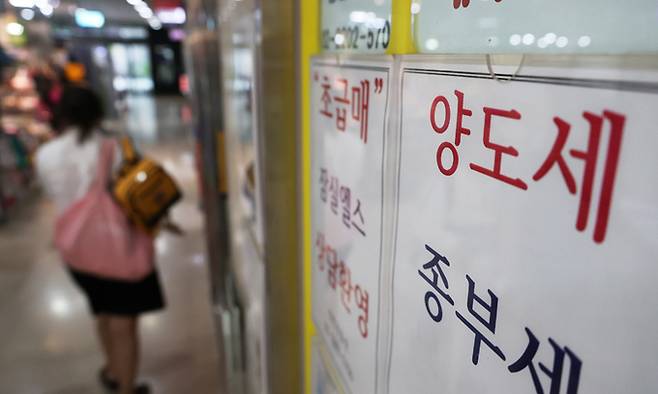 26일 양도세 상담 문구가 적힌 서울 잠실 공인중개사무소 앞을 시민이 지나고 있다. 연합뉴스