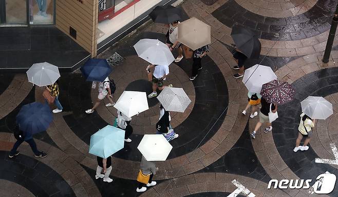 본격적인 장마가 시작된 지난 26일 서울 중구 명동에서 시민들과 외국인 관광객들이 우산을 쓰고 발걸음을 재촉하고 있다. 2023.6.26/뉴스1 ⓒ News1 김진환 기자