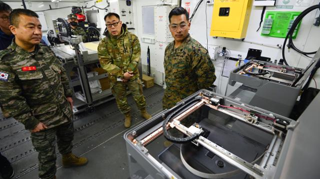 해병대 군수단 조경호(왼쪽) 단장이 2월 13일 경북 포항 미 해병대 캠프무적에서 열린 한·미 해병대 3D 프린팅 기술교류 전시회에서 미 해병대가 보유 중인 3D 프린터 장비에 대한 설명을 듣고 있다. 뉴스1