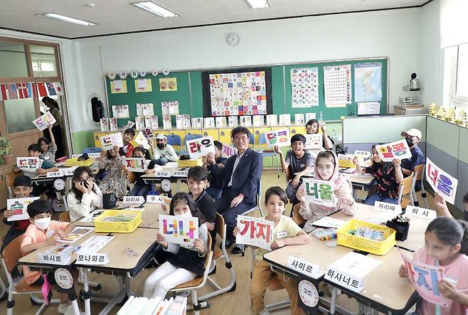 [울산=뉴시스] 구미현 기자 = 27일 오전 울산 동구 서부초등학교 한국어반에 재학중인 아프가니스탄 특별기여자 자녀들이 '순 우리말 카드'를 들어보이며 천창수 교육감과 기념촬영을 하고 있다. 2023.06.27. (사진=울산시교육청 제공) *재판매 및 DB 금지