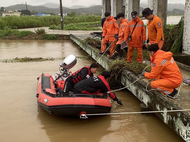 28일 오전 전남소방본부 소방대원들이 전남 함평군 엄다면 송로리 인근에서 전날 폭우로 불어난 하천 수문을 열다가 실종된 수문관리자 여성을 찾기 위한 수색 작업을 하고 있다./전남소방본부