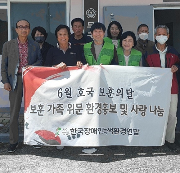 한국장애인녹색환경연합과 대한장애인환경협회 회원들이 6월 호국보훈의 달을 맞아 무궁화용사촌을 찾아 감사 물품을 전달하고 기념 촬영을 하고 있다. [사진=한국장애인녹색환경연합]