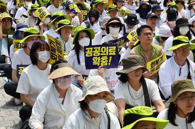 지난 27일 서울 용산구 대통령 집무실 인근에서 열린 결의대회에서 보건의료노조 조합원들이 팻말을 들고 있다. 연합뉴스