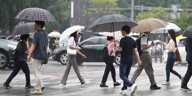 전국이 흐리고 대부분 지역에 비가 내리는 29일 오전 서울 광화문역 인근에서 시민들이 우산을 쓰고 발걸음을 옮기고 있다. /뉴스1