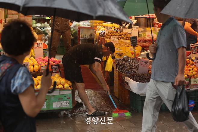 수도권 대부분 지역에 호우주의보가 발령된 29일 지난해 폭우로 침수 피해가 발생한 서울 동작구 남성사계시장에서 상인들이 차오르는 빗물을 치우고 있다.