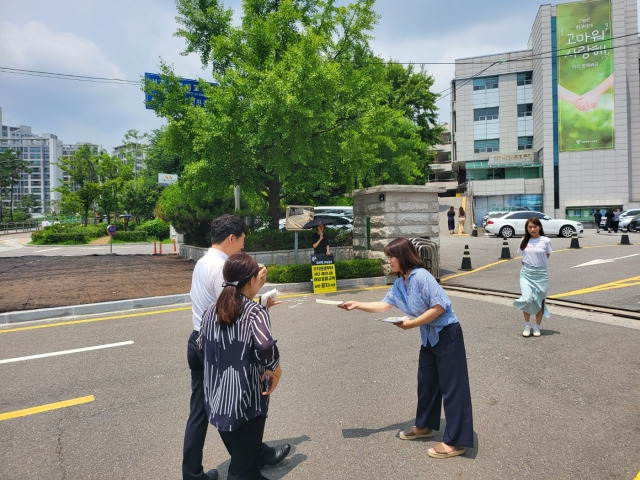 전국학부모단체연합 소속 회원이 지나가는 행인에게 '성혁명 교육 반대' 메시지가 담긴 전단지를 나눠주고 있다.