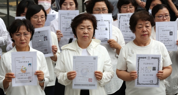 대한간호협회 소속 간호사 등이 지난 26일 오전 세종시 정부세종청사 보건복지부 앞에서 ‘간호법 허위사실 유포ㆍ불법진료 묵인 보건복지부 규탄’ 간호사 면허증 반납 기자회견을 하고 있다. 연합뉴스