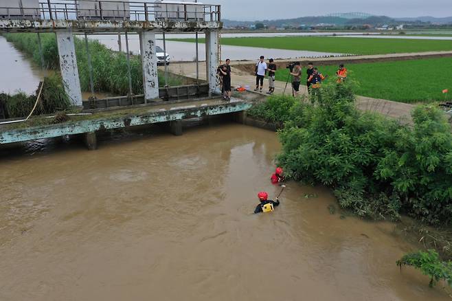 지난 28일 오후 전남 함평군 엄다면 하천에서 소방특수구조대원이 전날 밤 폭우 피해를 막으려다가 실종된 수리시설 감시원을 찾아 수중 수색을 하고 있다. ⓒ 연합뉴스