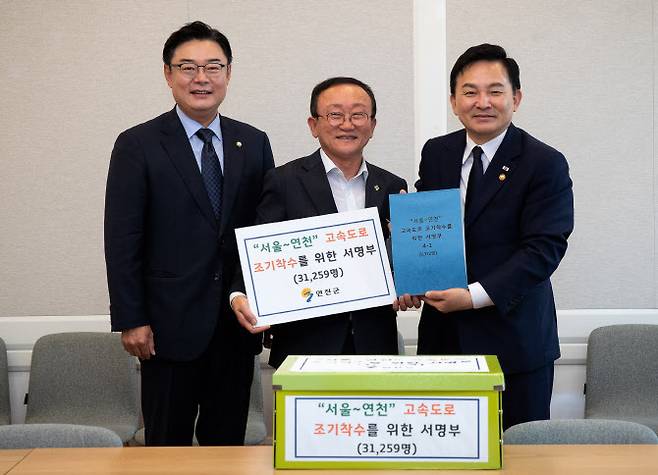 김덕현 군수(가운데)가 원희룡 장관(오른쪽)에게 서명부를 전달하고 기념촬영을 하고 있다.(사진=연천군 제공)