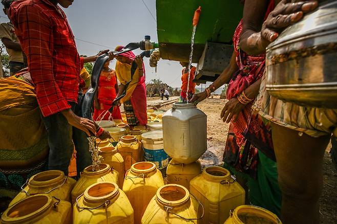 2022년 5월 20일 가뭄으로 물부족에 시달리는 인도 우타르프라데시주 라후리야 마을 사람들이 물을 공급받고 있다. 인도의 물 공급은 자연 기후 주기에 크게 의존하고 있기 때문에 가뭄에 특히 취약하다.