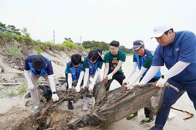 지난달, 바다의 날을 맞아 제너시스BBQ 그룹이 임직원들이 인천 용유해변에서 해변에 버려져 방치된 어업∙산업용 쓰레기를 회수하고 있다