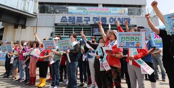 지난 14일 인천시 남동구 소래포구 전통어시장에서 상인들이 자정대회를 열고 '바가지요금' 근절 등을 결의하며 구호를 외치고 있다. 연합뉴스