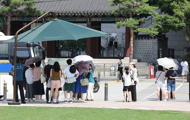 [서울=뉴시스] 권창회 기자 = 폭염 위기경보 단계가 '경계'로 격상된 1일 오후 서울 중구 서울광장에서 시민들이 그늘에서 신호를 기다리고 있다. '경계' 단계는 전국 40%(72개) 이상 지역에서 일 최고체감온도 33도 이상인 상태가 3일 이상 지속될 것으로 예상될 때 발령한다. 2023.07.01.