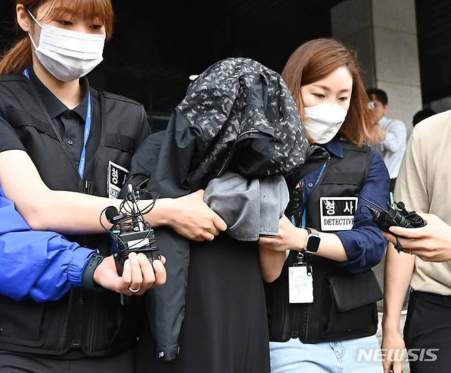 [수원=뉴시스] 김종택 기자 = 영아 2명을 살해한 뒤 시신을 수년간 냉장고에 보관해 온 혐의로 구속된 친모 고모씨가 30일 경기도 수원남부경찰서에서 검찰로 송치되고 있다. '수원 냉장고 영아 시신' 사건을 수사중인 경찰은 고모씨의 혐의를 영아 살해에서 살인과 사체은닉으로 변경했다. 또한 고씨의 남편이자 친부인 40대 남성 A씨를 참고인 신분에서 살인 방조 혐의를 적용한 피의자 신분으로 전환했다. 2023.06.30. jtk@newsis.com