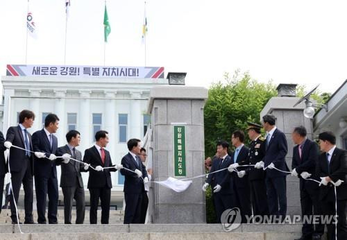 지난달 12일 강원특별자치도청에서 김진태 도지사와 실·국장 등이 가림막을 떼어내고 있다.[연합뉴스 자료 사진]