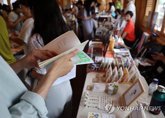 전국 독립출판물 한자리에 (전주=연합뉴스) 나보배 기자 = 1일 전북 전주시 덕진구 연화정도서관에서 열린 독립출판 북페어 '2023전주책쾌'에서 시민들이 책을 읽어보고 있다. 2023.7.1 warm@yna.co.kr