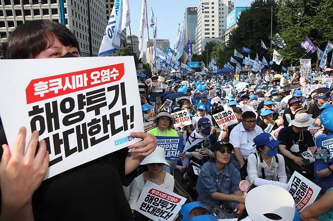 참석자들이 후쿠시마 오염수 해양투기를 반대하는 손팻말을 들고 있다. 김봉규 선임기자