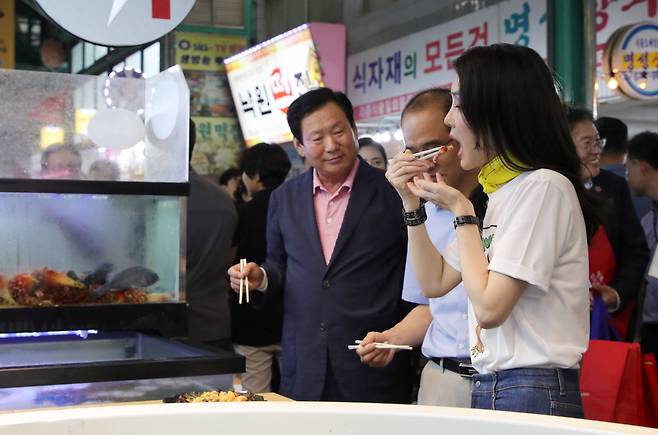 김건희 여사가 3일 오후 강원도 강릉시 중앙·성남시장을 방문해 횟집에서 오징어회를 시식하고 있다. [연합]