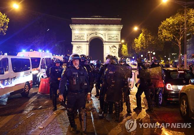 파리 개선문 앞 경찰 (파리 AFP=연합뉴스) 프랑스 전역에서 폭력 시위가 이어지는 가운데 경찰이 1일(현지시간) 밤 파리 개선문 앞을 지키고 있다. 2023.7.2 photo@yna.co.kr