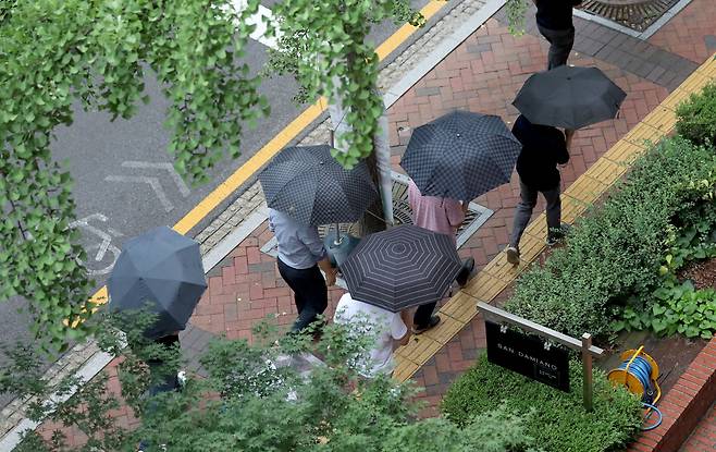 전국에 장맛비가 내린 4일 오후 서울 중구 정동길에서 우산을 쓴 시민들이 발걸음을 재촉하고 있다. /뉴스1