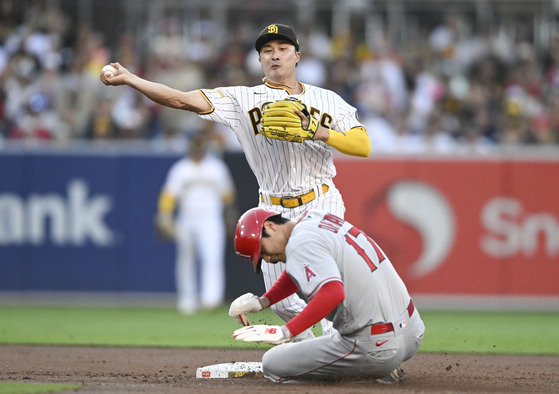 San Diego Padres second baseman Kim Ha-seong, top, throws over Shohei Ohtani of the Los Angeles Angels as he turns a double play during the first inning of a game in San Diego on Monday. The Padres went on to win the game 10-3.  [AP/YONHAP]