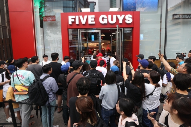 지난달 26일 오전 한국 첫 매장을 개점하는 미국 햄버거 브랜드 ‘파이브가이즈’ 강남점 앞에서 시민들이 햄버거를 구매하기 위해 줄을 서 있다. [사진 출처 = 연합뉴스]