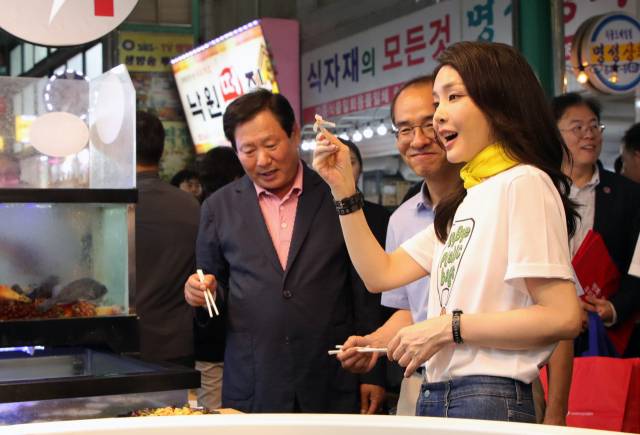 ▲김건희 여사가 3일 오후 강원도 강릉시 중앙·성남시장을 방문해 횟집에서 오징어회를 시식하고 있다. ⓒ연합뉴스