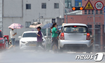 전국 대부분 지역에 폭염특보가 내려진 3일 오후 경기 수원시 장안구 수원종합운동장 인근 도로에 설치된 노면 빗물분사시스템에서 도로 열기를 낮추기 위해 물이 분사되고 있다. 2023.7.3/뉴스1 ⓒ News1 김영운 기자