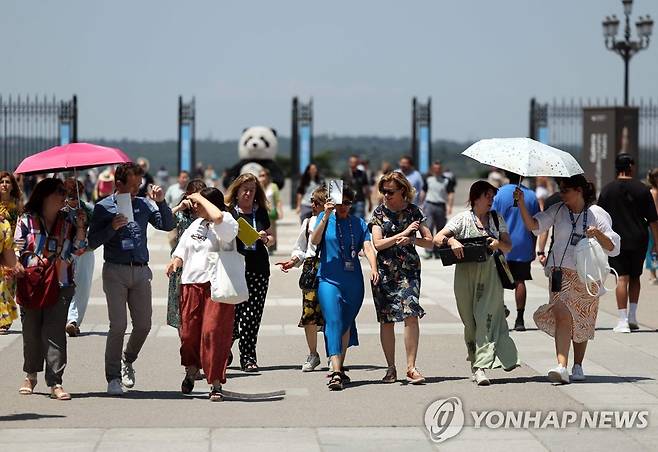 스페인 마드리드에서 양산을 쓰고 걷는 관광객들 [AFP=연합뉴스]